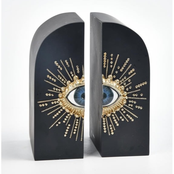 This super embossed sunburst eye bookends are matt black rounded blocks with a central blue eye and embossed gold eyelashes radiating out 11 x 13 x 18cm